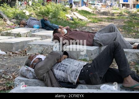 Dehradun, Uttarakhand/Indien - September 06 2020: Zwei Männer ruhen im Schatten und tragen eine Gesichtsmaske. Stockfoto