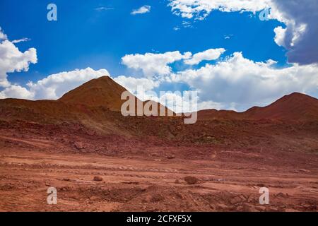 Aluminiumerz-Steinbruch. Bauxit-Tonerde-Tagebau. Haufen leerer Steine und Straßen. Blauer Himmel mit Wolken. Stockfoto