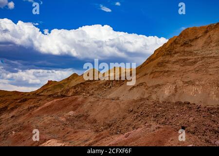 Bauxit Tagebau (Open Cast). Farbe Aluminium Erz Steinbruch. Ein großer gelber Haufen leerer Felsen. (Schlackenhaufen). Am blauen Himmel mit Wolken. Stockfoto