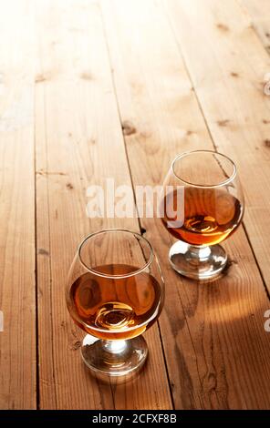 Gläser Cognac auf altem Holztisch Stockfoto
