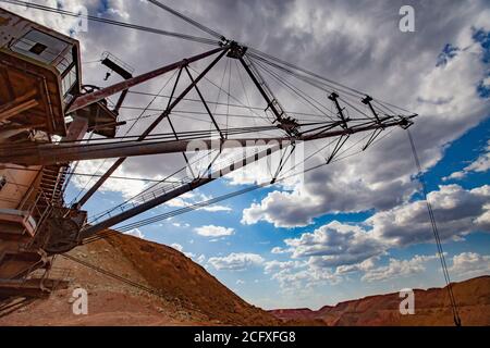 Aluminiumerz-Steinbruch. Bauxit-Tonerde-Tagebau. Walking Dragline Bagger. Schwere elektrische Maschine. Weitwinkelansicht. Mast mit Kabeln auf rot Stockfoto