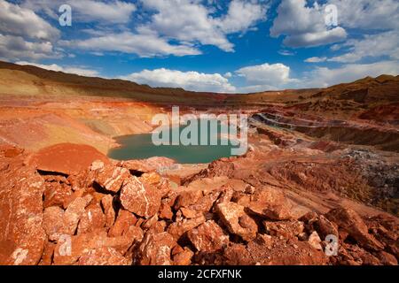 Grüner Steinbruch See in Bauxit Mine. Am blauen Himmel mit Wolken am Sommertag. Aluminiumerz Tagebau (Tagebau, Tagebau) Stockfoto