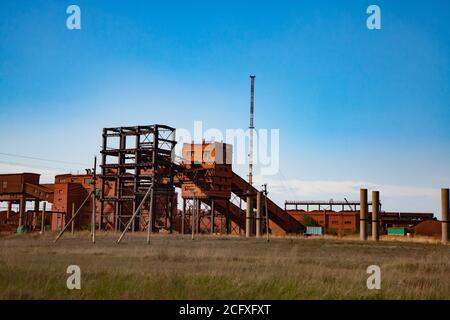 Verladung und Eisenbahntransport Terminal. Roter Lehmstaub. Aluminiumerzabbau. Bauxit Tonerde Tagebau. Tiefblauer Himmel Hintergrund. Stockfoto