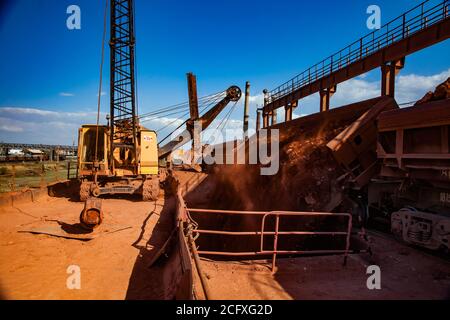 Bauxit-Tonerde-Tagebau. Verladung und Eisenbahntransport Terminal. Bagger beladen Aluminiumerz. Hopper Auto Zug auf Schienen.. Stockfoto