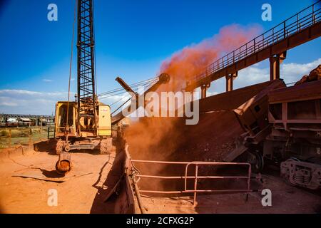 Bauxit-Tonerde-Tagebau. Verladung und Eisenbahntransport Terminal. Beladen von Aluminiumerz vom Schlitten zum Trichter. Hopper Auto Zug auf Schienen. Stockfoto