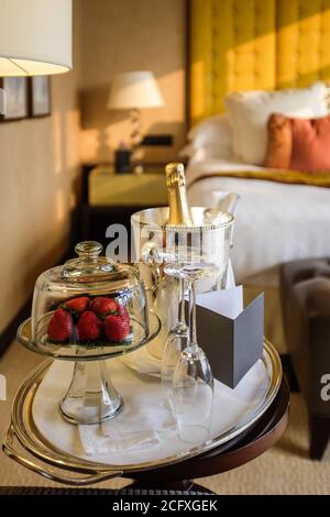 Ein Teller Erdbeeren und eine Flasche Champagner erwarten die Gäste in einem luxuriösen Hotelzimmer in Hongkong. Stockfoto