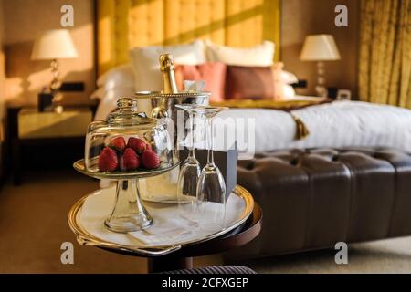 Ein Teller Erdbeeren und eine Flasche Champagner erwarten die Gäste in einem luxuriösen Hotelzimmer in Hongkong. Stockfoto