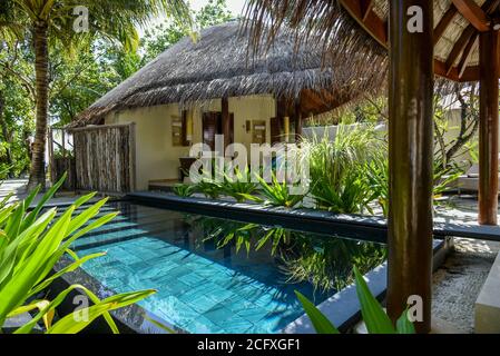 Eine private Villa mit einem Bad im Freien und einem Tauchbecken im Garten in einem Luxusresort auf den Malediven. Stockfoto