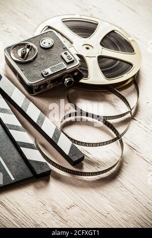 Vintage film claper mit Filmrolle auf Holz gelegt. Filmammakers Ausrüstung Hintergrund Stockfoto