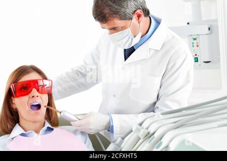 Frau bekommt Laserbehandlung beim Zahnarzt Stockfoto