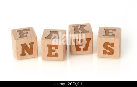 Fake News Wörter auf Holzwürfel, weißer Hintergrund Stockfoto