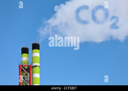 Grüne Fabrikrohre mit symbolischer Emission einer co2-Wolke Stockfoto