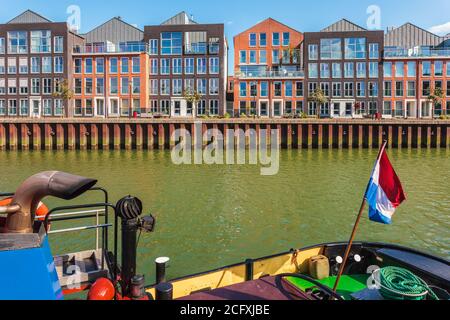 Moderne Häuser in Dordrecht, Niederlande mit altem Schlepper vor Stockfoto