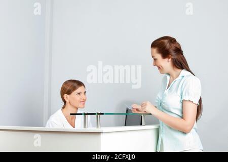 Frau mit Smartcard beim Einchecken an der Rezeption Stockfoto