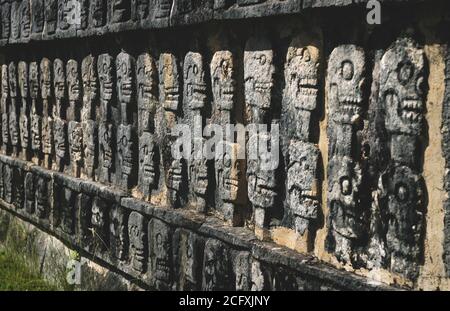 Wand mit geschnitzten Schädeln in einem Maya-Tempel aus Stein in Chichen Itza, Yucatan, Mexiko Stockfoto