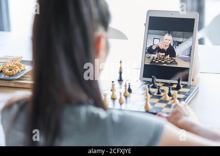 Zwei Frauen spielen Schach in Video-Chat online auf Laptop Computer zu Hause Stockfoto