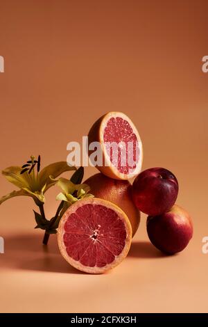 Stillleben mit Früchten und Orange Töne, mit Orangen, Granatapfel und Pfirsiche auf einem orangen Hintergrund. Stockfoto