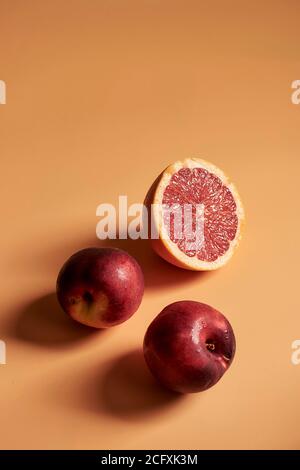 Stillleben mit Früchten und Orange Töne, mit Orangen, Granatapfel und Pfirsiche auf einem orangen Hintergrund. Stockfoto