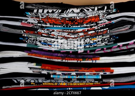 Selektiver Fokus Foto von T-Shirts mit hellen Drucken, gedruckt von Siebdruck. Serigraphie Produktion. Drucken von Bildern auf T-Shirts in einem Designstudio. Stockfoto