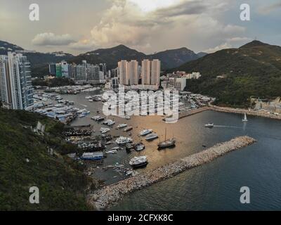 Eine Luftaufnahme über dem Aberdeen Typhoon Shelter, die Yachten in Aberdeen Marina und Wohnblocks im Sham Wan Distrikt, Hong Kong zeigt. Stockfoto