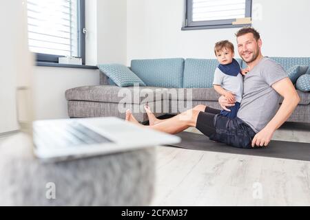 Vater und Sohn spielen Video-Streaming auf Laptop-PC bei Zuhause im Wohnzimmer Stockfoto