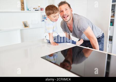 Vater und Sohn spielen und sind dumm zusammen Die Küche und Spaß haben Stockfoto