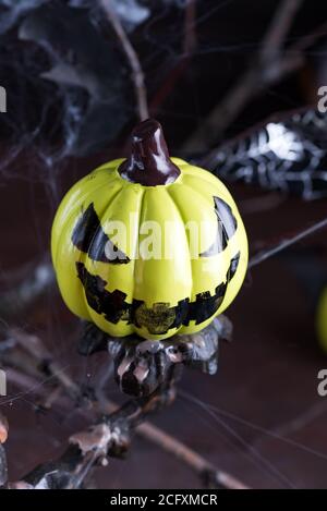 Kreative Dekoration für Helloween Party mit flyig gruselig lachenden Kürbis vor abstraktem schwarzem Hintergrund, Kopierraum. Halloween-Konzept. Stockfoto