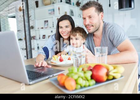 Familie mit Kind feiert Geburtstag mit Kuchen und Obst in Video-Chat zu Hause Stockfoto