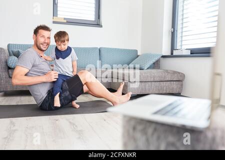 Vater und Kind im Wohnzimmer spielen Video-Chat Auf Laptop-Computer zusammen Stockfoto