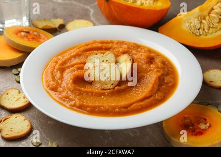 Knuspriges Komfortessen aus Kürbispüree mit Croutons auf einem grauen Teller in Nahaufnahme Stockfoto