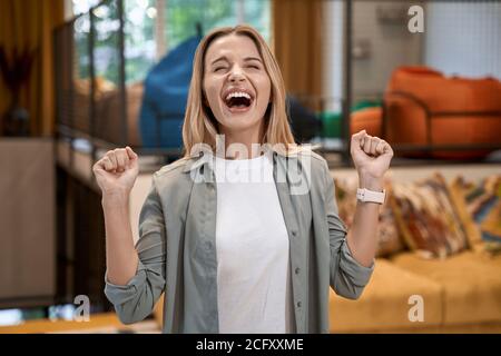 Gute Nachrichten bei der Arbeit, Porträt einer jungen aufgeregt kaukasischen Frau feiert Erfolg und glücklich fühlen, während im modernen Büro stehen Stockfoto