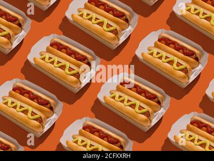 Hotdogs mit Senf und Ketchup in Kartonverpackung über Orange Hintergrund Stockfoto