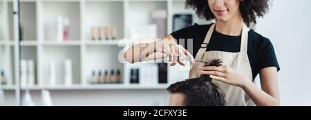 Nahaufnahme von Friseur schneiden Haare von Mann in Schönheitssalon Interieur, Panorama, freien Raum Stockfoto