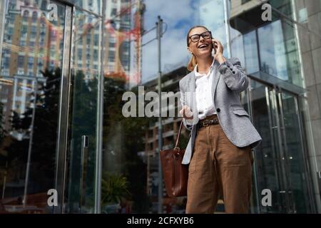 Kommunikation. Portrait von glücklich modische Geschäftsfrau tragen Brillen und klassische tragen Gespräch auf Handy Stockfoto