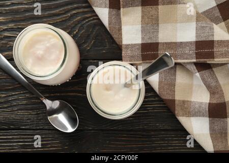 Glas Gläser Joghurt, Löffel und Serviette auf Holzhintergrund Stockfoto