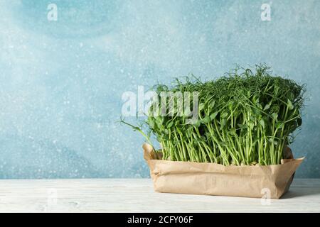 Grüne Erbsen sprießen vor blauem Hintergrund, Platz für Text Stockfoto