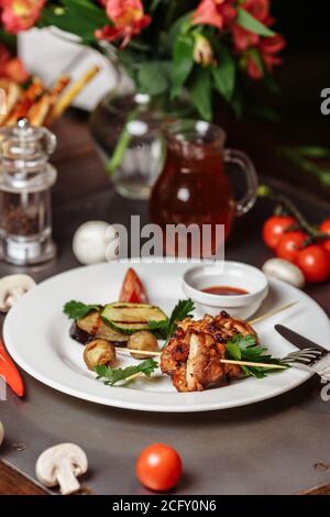 Gegrillte marinierte pute oder Hühnerfleisch Schisch Kebab Spieße mit Ketchup-Sauce und gegrilltes Gemüse auf rustikalem Holztisch Hintergrund Stockfoto