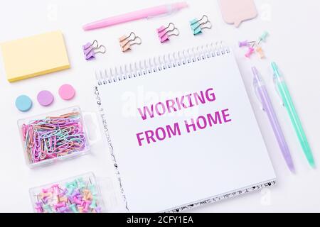 Home Office-Arbeitsplatz mit Notebook und pastellfarbenem Arbeitszubehör auf rosa Hintergrund. Arbeiten von zu Hause Konzept. Draufsicht - Bild Stockfoto