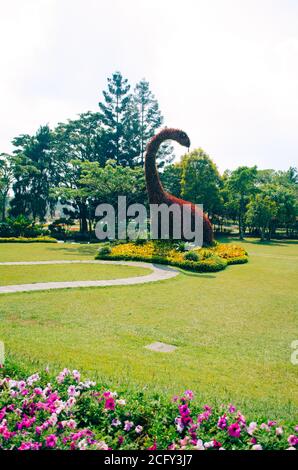 Bogor, Indonesien - EIN Blick auf den blühenden Park Taman Bunga Nusantara an einem bewölkten Nachmittag mit Blick auf einen Busch in Form eines pflanzenfressenden Dinosauriers. Stockfoto