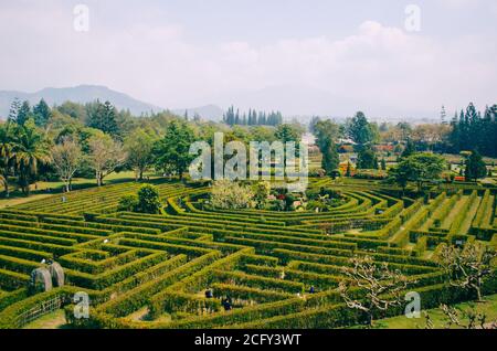 Bogor, Indonesien - EIN Blick auf den Blumen-Themenpark Taman Bunga Nusantara an einem bewölkten Nachmittag mit einem Blick von oben auf ein Labyrinthfeld mit Menschen Stockfoto