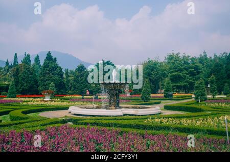 Bogor, Indonesien - EIN Blick auf den Blumen-Themenpark Taman Bunga Nusantara an einem bewölkten Nachmittag mit Blick auf einen Brunnen in der Mitte des Bilds Stockfoto