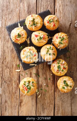 Frisch gebackene Mais-Muffins mit Krabbenfleisch, Kräutern und Käse aus der Nähe auf einem Schieferbrett auf dem Tisch. Vertikale Draufsicht von oben Stockfoto