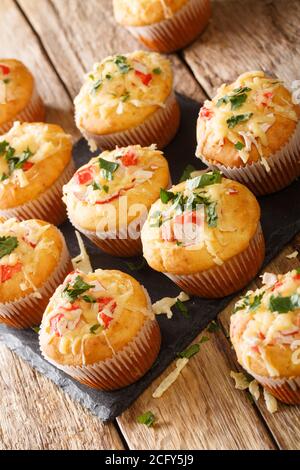 Leckere Snack-Muffins mit Krabbenfleisch und Käse aus der Nähe auf einem Schieferbrett auf dem Tisch. Vertikal Stockfoto