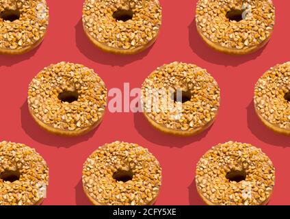 Viele leckere Donuts mit Schokoladenglasur und Nüsse bestreut Rosa Hintergrund Stockfoto