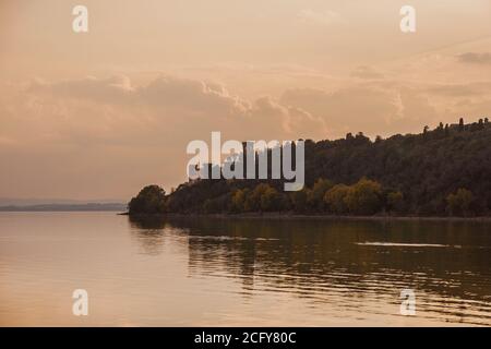 Romantisches Abendlicht über dem Trasimenischen See und der Isola Maggiore (Großinsel) mit alten Burgruinen in Umbrien Stockfoto