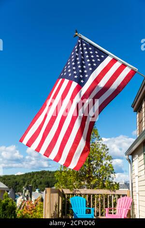 Sterne und Streifen amerikanische Flagge flattert im Wind, vor einem Gebäude in Bar Harbor, maine, USA. Sommer blauer Himmel Hintergrund. Stockfoto
