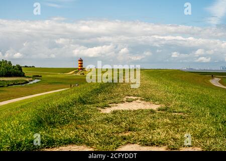 Blick auf Pilsum Leuchtturm in Ostfriesland mit Touristen zu Fuß Rund um den Deich und Fotografieren Stockfoto