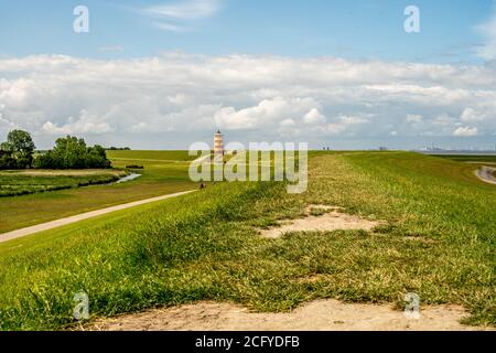 Blick auf Pilsum Leuchtturm in Ostfriesland mit Touristen zu Fuß Rund um den Deich und Fotografieren Stockfoto