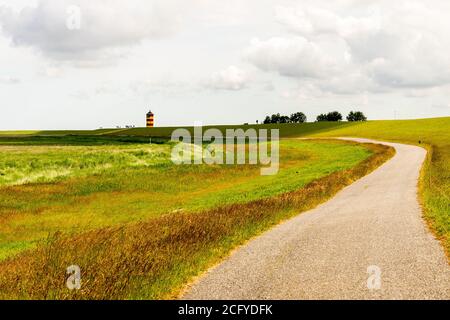 Blick auf Pilsum Leuchtturm in Ostfriesland mit Touristen zu Fuß Rund um den Deich und Fotografieren Stockfoto
