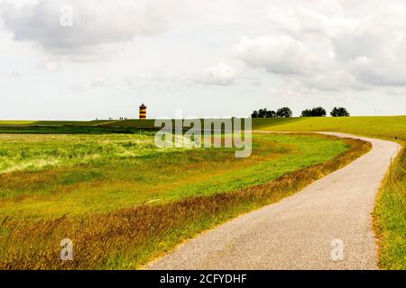 Blick auf Pilsum Leuchtturm in Ostfriesland mit Touristen zu Fuß Rund um den Deich und Fotografieren Stockfoto